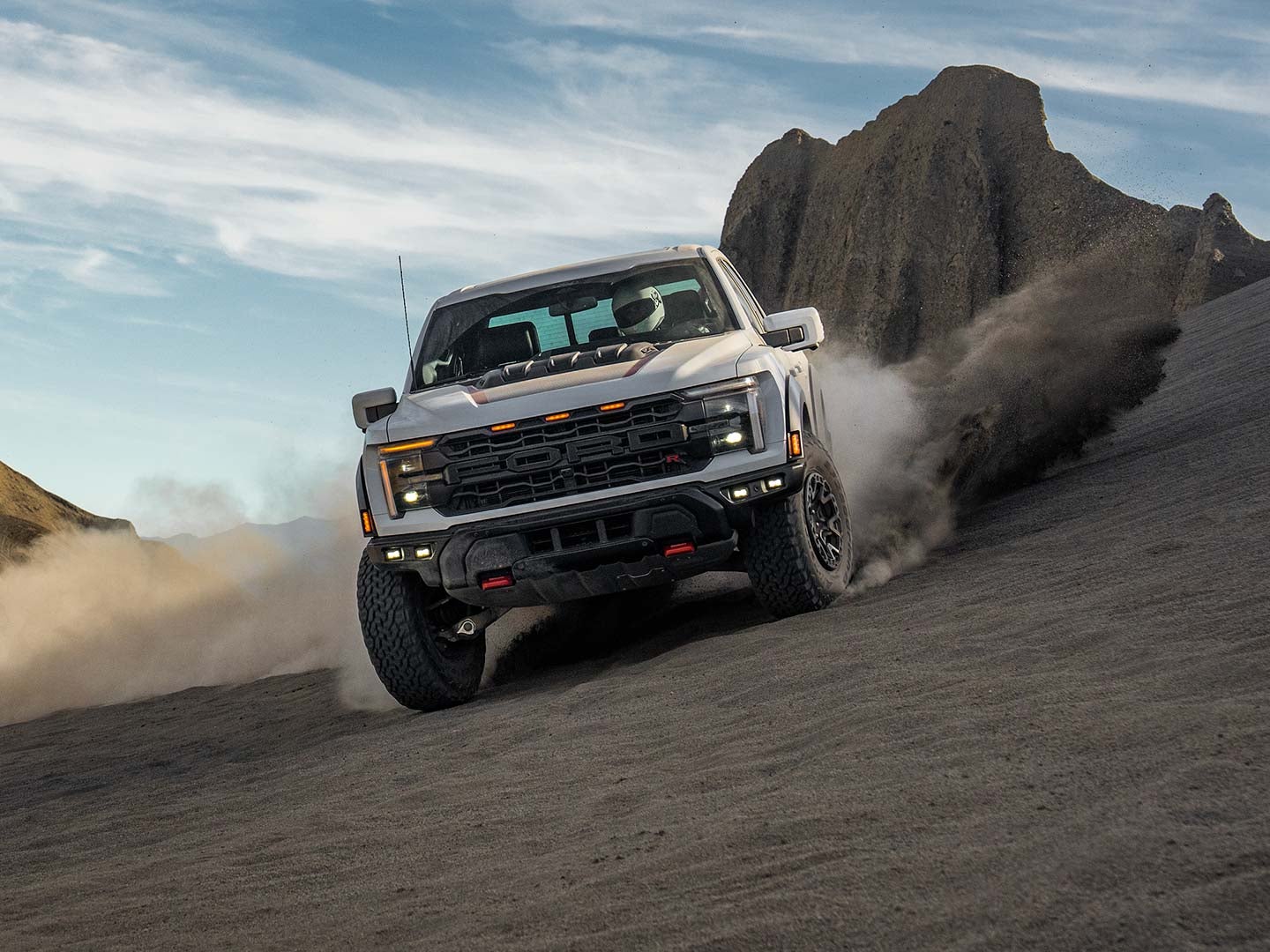 2024 F-150® Raptor R™ being driven in the desert kicking clouds of sand
