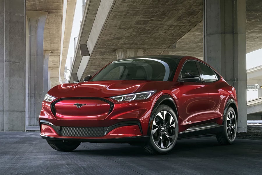 Red Ford Mustang Mach-E SUV parked under an overpass